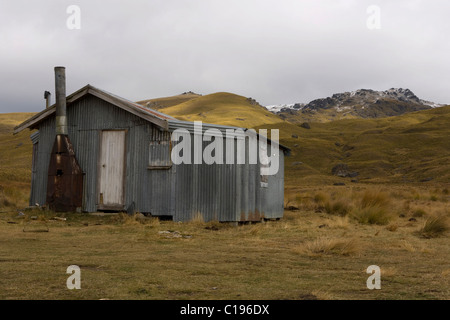 Verlassene Wellblech Hütte in einer hügeligen Landschaft, Nevis überqueren, Cromwell, Otago, Südinsel, Neuseeland Stockfoto