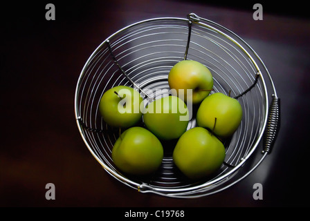 Gruppe von grünen Äpfeln im Drahtkorb Stockfoto