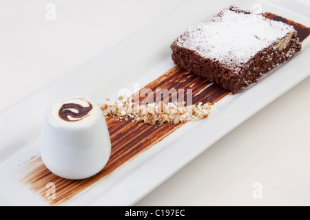 Süße Dessert: Schokoladen-Brownie mit Weinbrand Creme & karamellisierte Haselnuss garnieren 116486 Food Stockfoto