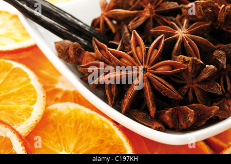 Getrocknete Orangenscheiben mit Vanille und Sternanis in Schüssel weiß Stockfoto