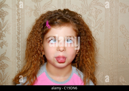 lustiges Mädchen hässlich Gesichtsausdruck schielen Schielen auf Retro-Tapete Stockfoto