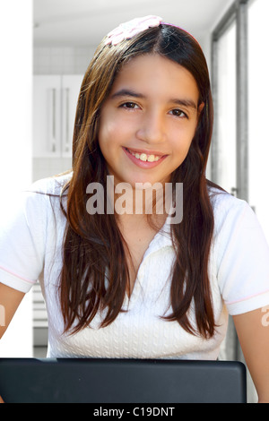 Lateinischen Teenager Student lächelnd Holding Laptop innen weißes Haus Stockfoto