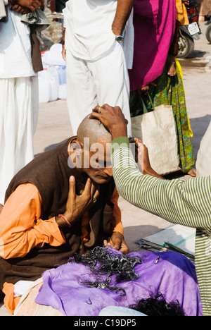 Barbier rasieren des Kopfes eines Pilgers, Haridwar, Uttarakhand, Indien Stockfoto