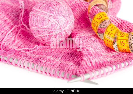 Handgefertigte Nadel gestrickte rosa Leinwand, Knäuel und und Maßband Stockfoto