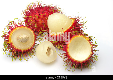 Behaarte, roten Rambutan Früchte (Nephelium Lappaceum). Ganze Früchte, einige geschält, zeigt weiße essbare Fruchtfleisch und Samen. Schuss auf weiß. Stockfoto