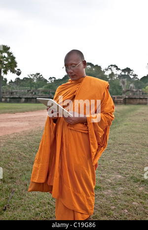 Mönch an Angkor Wat, ein Tablet zu betrachten. Kambodscha Stockfoto