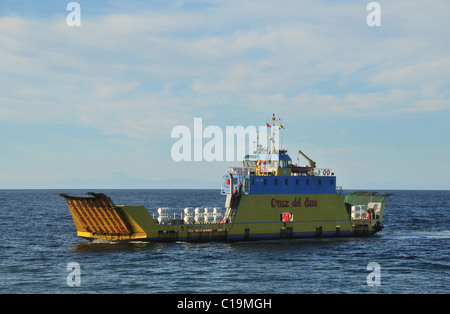 Gelbe Cruz del Sur Autofähre auf blauen Wassern des Chacao Kanal, mit Blick auf trübe Anden und Volcan Michinmahuida, Chile Stockfoto