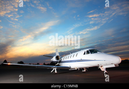 Porträt eines corporate Jets auf dem Rollfeld gegen ein Abendhimmel. Stockfoto