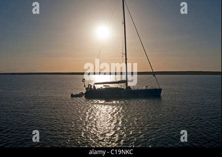Private Segelyacht, die Silhouette bei Sonnenuntergang während vor Anker Stockfoto