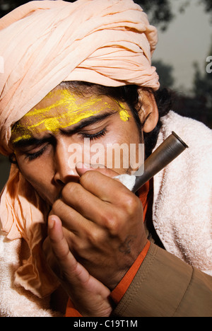 Nahaufnahme von einem Sadhu Rauchen eine Chilam, Haridwar, Uttarakhand, Indien Stockfoto