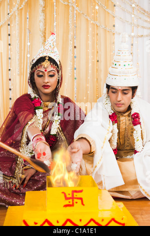 Durchführung von Yajna in Bengali Hochzeit paar Stockfoto