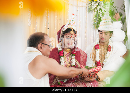 Durchführung von religiösen Zeremonie in Bengali Hochzeit paar Stockfoto