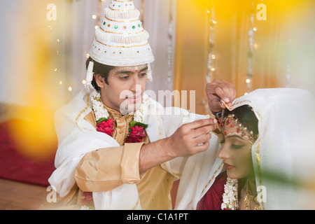 Durchführung Sindoor Daan Zeremonie in Bengali Hochzeit paar Stockfoto