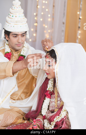 Durchführung Sindoor Daan Zeremonie in Bengali Hochzeit paar Stockfoto