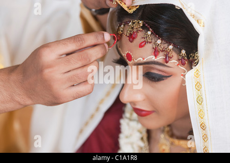 Durchführung Sindoor Daan Zeremonie in Bengali Hochzeit paar Stockfoto