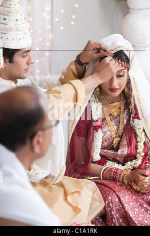 Durchführung Sindoor Daan Zeremonie in Bengali Hochzeit paar Stockfoto