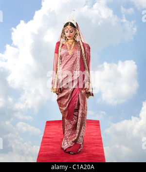 Braut in Bengali Kleid stehend auf einem Teppich in den Wolken Stockfoto