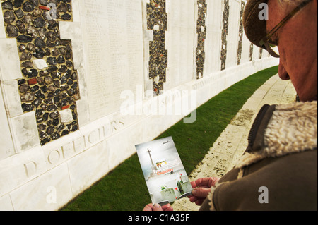 Ältere Männchen Tyne Cot Friedhof Broschüre zu lesen, während im Vordergrund stehen Namen der Toten auf dem Friedhof Stockfoto