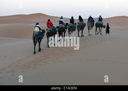 Touristen auf einem Kamel Campingplatz Reise in die Wüste Sahara, Erg Chebbi, Marokko, Nordafrika. Stockfoto