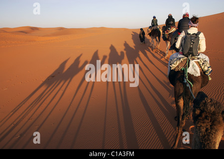 Touristen auf einem Kamel Campingplatz Reise in die Wüste Sahara, Erg Chebbi, Marokko, Nordafrika. Stockfoto