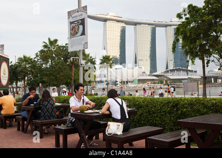 Paar Essen in Makansutra Fresser Bay Foodcourt mit Marina Buchten Sands im Hintergrund.  Marina Bay, Singapo Stockfoto