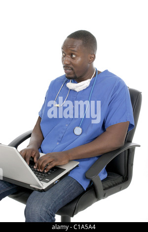 Gut aussehend männlichen Arzt oder das Pflegepersonal, die sitzen in einem Bürostuhl arbeitet an einem Laptop-Computer. Stockfoto