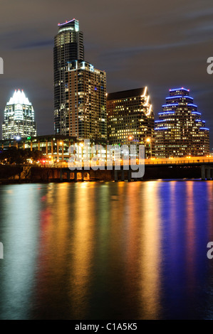 Skyline von Austin bei Nacht Lady Bird Lake / AUSTIN, Texas – die Skyline von Downtown AUSTIN wurde nachts vom Lady Bird Lake aus fotografiert. Die Lichter der Stadt und die blauen LED-Linien des gestuften 300 West Sixth Gebäudes zeigen sich in langen Reflexen über das Wasser. Lady Bird Lake, ein Stauwerk des Colorado River, liegt im Herzen des 16 km langen Wander- und Radweges von Austin, einem der am stärksten genutzten städtischen grünen Korridore in Texas. Stockfoto