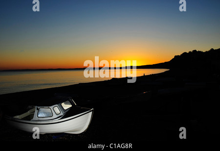 Budleigh Strand Sonnenuntergang mit Boot im Vordergrund, die auf der Suche nach Sandy Bay Stockfoto