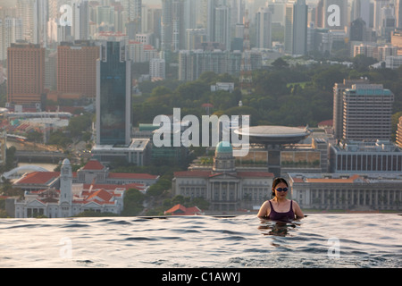 Frau, Schwimmen im Pool im Marina Bay Sands SkyPark mit Skyline der Stadt im Hintergrund.  Marina Bay, Singapur Stockfoto