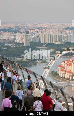 Besucher blicken auf die Skyline von Singapur von der Aussichtsplattform des Marina Bay Sands SkyPark.  Marina Bay, Singapur Stockfoto