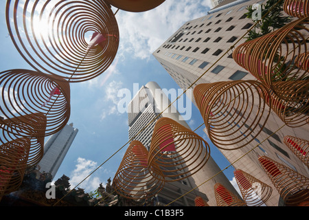 Spirale Weihrauch Spulen mit Skyline der Stadt im Hintergrund bei Wak Hai Cheng Bio Tempel, Raffles Place, Singapur Stockfoto