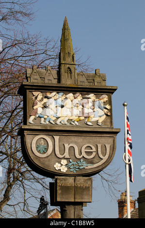 Geschnitzte hölzerne Ortstafel bei Olney Buckinghamshire England UK bekannt für die jährliche Pfannkuchen-Rennen Stockfoto