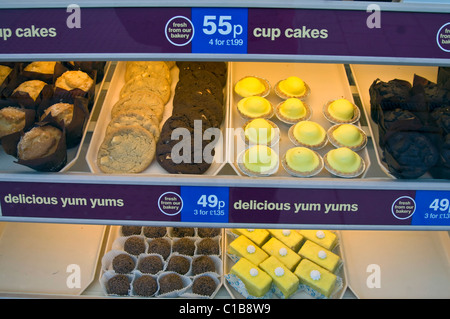 Auswahl an ungesunden Kuchen auf dem Display im schottischen High Street-Bäckerei-Fenster Stockfoto