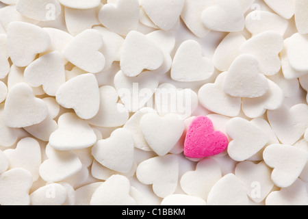 Hintergrund mit weißen Herzen und ein rosa Herz Stockfoto