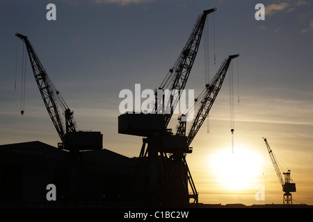 Sonnenuntergang über die Krane bei BAE Systems-Werft in Govan, Glasgow, Schottland, UK Stockfoto