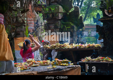 Frau Morgen Opfergaben am belebten Tempel in der Nähe von den wichtigsten Markt in Ubud Stockfoto