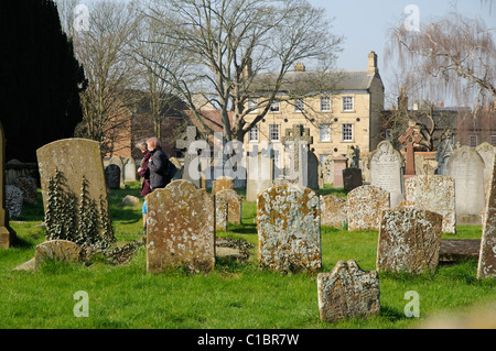 Friedhof und Frauen gehen in die Kirche zu St. Peter & St-Paul-Kirche in Olney Buckinghamshire England UK Stockfoto