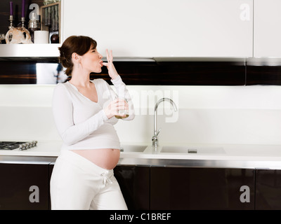 Schwangere Frau essen Honig aus Glas Stockfoto