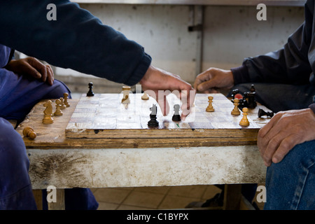 Fischer spielt "Dame" Brettspiel. Auch genannt "Zugluft" Brettspiel. Fischereistadt Hütten, Narsaq, Süd-Grönland Stockfoto