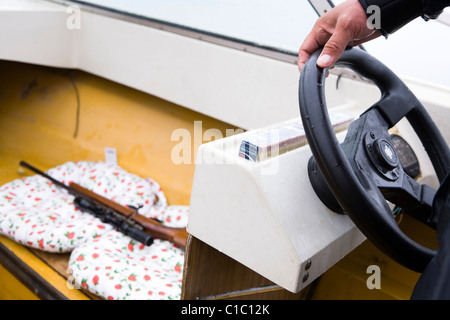 Jäger sein Boot, sein Gewehr in unmittelbarer, Süd-Grönland Segeln zu versiegeln. Stockfoto