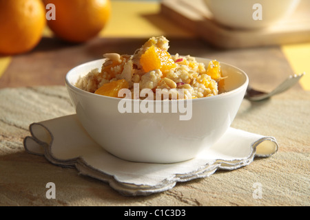 Huhn und Orange Salat mit Couscous und bestreut mit Pinienkernen in einer weißen Schüssel Stockfoto