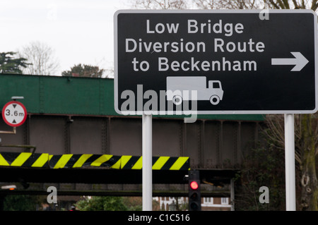 Ein Schild für eine Abzweigung Weg zum Beckenham niedrige Brücke vor Shortland Bahnhof (im Hintergrund) zu vermeiden. Stockfoto