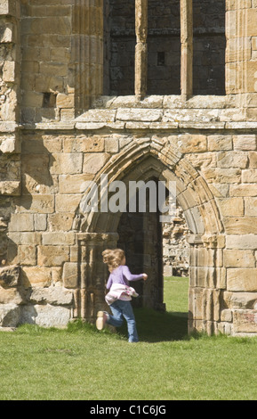 Ein Kind läuft durch einen alten Torbogen in den Ruinen von Egglestone Abbey, Teesdale, County Durham, Großbritannien Stockfoto