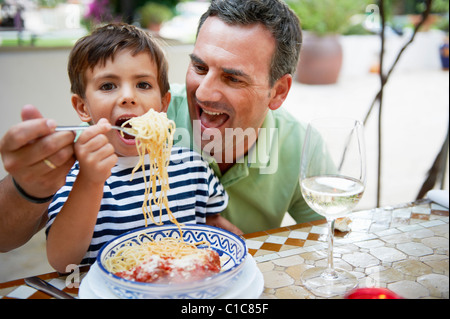 Vater und Sohn Spaghetti-Essen Stockfoto