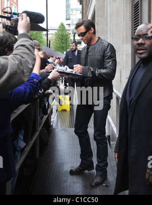 Hugh Jackman freut sich Autogramme nach Glaubensbekennenden Fans beim Verlassen der Radio One Studios. Die antipodean Stück ist Stockfoto