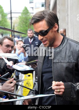 Hugh Jackman freut sich Autogramme nach Glaubensbekennenden Fans beim Verlassen der Radio One Studios. Die antipodean Stück ist Stockfoto