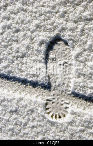 Menschlicher Fuß und Fahrrad Rad Abdruck im Schnee Stockfoto