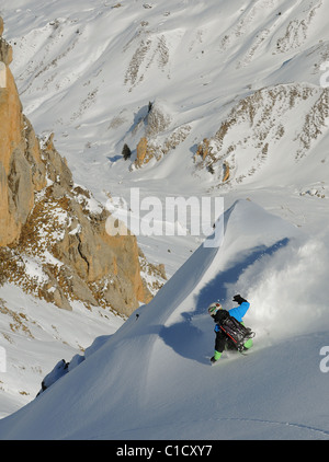 Ein Snowboarder schnitzt eine Wende im Tiefschnee abseits der Pisten in Les Avals Bereich des Skigebietes Courchevel in den französischen Alpen. Stockfoto