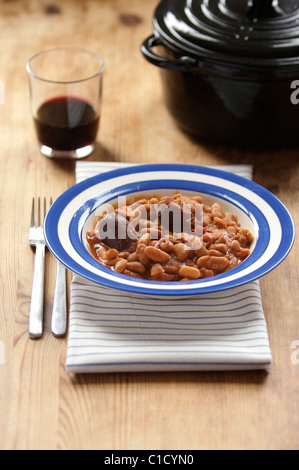 Traditionelle französische "Cassoulet" Eintopf mit einem Glas Rotwein und einem Dutch oven Stockfoto