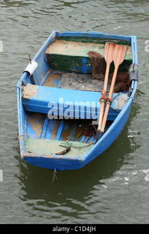 Leere blaue Fischerboot auf dem Wasser. Zwei Ruder liegt drin. Alvor, Algarve, PORTUGAL Stockfoto